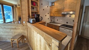 Una cocina moderna con armarios de madera, horno empotrado y cafetera.