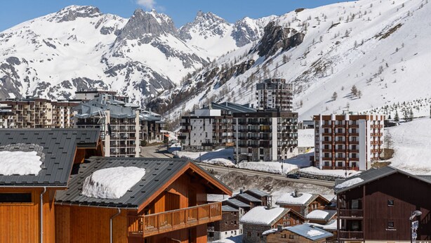 A mountain resort with wooden buildings and modern apartments, featuring snow-covered peaks in the background. - Comfortable studio with balcony in Tignes Le Lac for 4 people (Tignes)