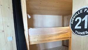 Une chambre avec des lits superposés, sur laquelle est apposée une pancarte indiquant le numéro de chambre : 21.
