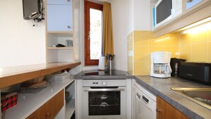 A compact kitchen with a built-in oven, a microwave, and a coffee maker. - Quiet Duplex with Balcony - 6 pers, Charmettoger (Les Arcs 1800)