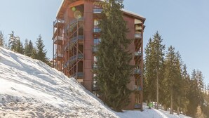 A multi-story building with balconies and a ski slope in the background. - Quiet Duplex with Balcony - 6 pers, Charmettoger (Les Arcs 1800)