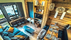 Un salon moderne avec un canapé, une table basse et un coin repas comprenant des assiettes et un saladier.