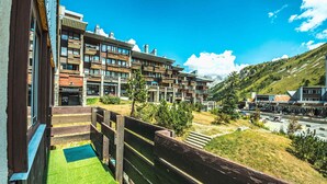 Un hôtel moderne à plusieurs étages, doté de terrasses extérieures et offrant une vue sur un paysage montagneux.