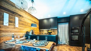 Une cuisine moderne avec des murs en bois, un îlot central et des appareils électroménagers intégrés.