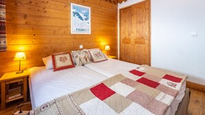 Ett mysigt rum med träpanel, en säng, två sänglampor och en affisch på väggen.