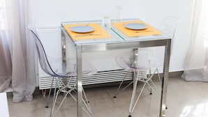 A modern dining area with a glass table and metal chairs. - Beautiful Apt. close to Monastiraki (Athens)