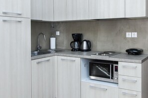 A modern kitchen with a built-in microwave, coffee maker, and kettle. - Beautiful Apt. close to Monastiraki (Athens)