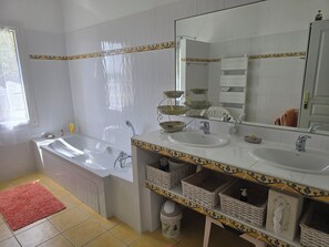 A bathroom with a bathtub, two sinks, a large mirror, and wicker baskets on the vanity. - Pech Ferrat, Pleine Campagne sur 1 Ha Arboré, vue sur la Vallée et les Coteaux (Saint-Amans-du-Pech)