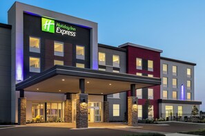 A Holiday Inn Express hotel with a modern facade, large windows, and a covered entrance area.