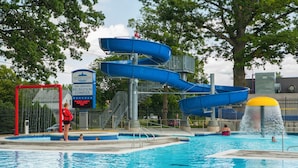 A swimming pool with a water slide and a lifeguard stand. - Holiday Inn Express Strathroy by IHG (Adelaide Metcalfe)