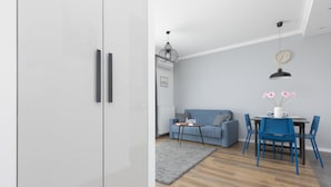 Una sala de estar moderna con un sofá, una mesa de comedor con sillas y una alfombra gris.