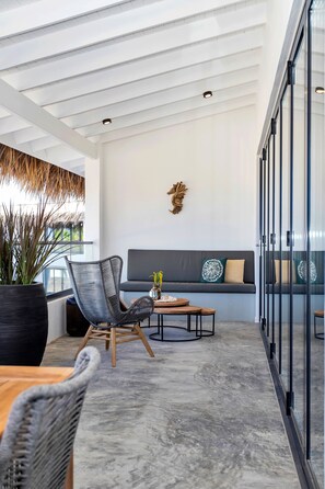 A modern interior with a seating area, a large potted plant, and a decorative wall piece.