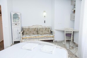 A room with a bed, a white cabinet, a patterned sofa, and a desk. - Beautiful Apartment in Pagkrati-GTD95601 (Athens)