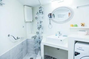 A modern bathroom with a shower, a sink, a mirror, and a radiator. - Beautiful Apartment in Pagkrati-GTD95601 (Athens)