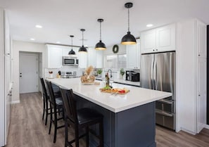A modern kitchen with a central island, stainless steel appliances, and pendant lighting. - Players Paradise-Private Pool-Golf-Shuffle Board (Scottsdale)