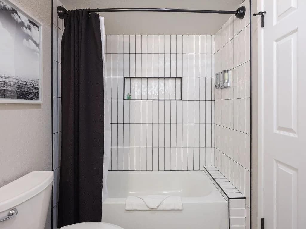 Un baño con bañera, inodoro y cortina de ducha.