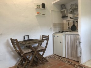 Køleskab, kaffe-/temaskine, køkkentøj/tallerkener/redskaber, spisebord