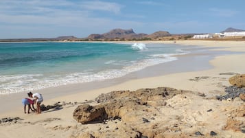 Na praia, espreguiçadeiras, toalhas de praia