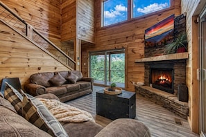 A wooden interior with a fireplace, a sofa, and a staircase. - Appalachian Lookout-10 minutes to Pigeon Forge, 5 to Gatlinburg! Hot tub&Games! (Gatlinburg)