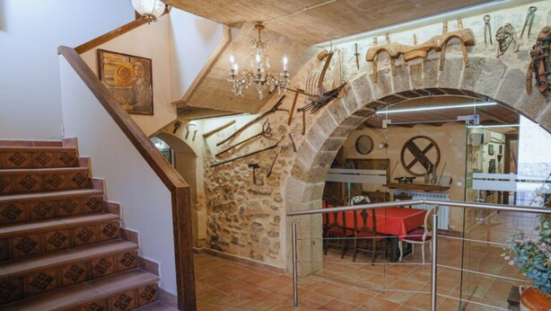 Una escala de pedra que condueix a una zona de menjador amb un penjoll, decoració rústica i vistes a l'interior.