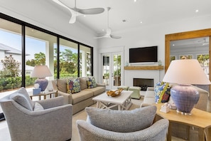 A modern living room with a sofa, chairs, a coffee table, and a fireplace.
