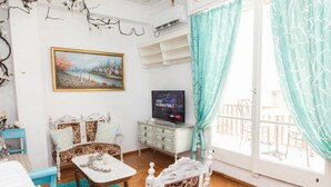 Uma sala de estar aconchegante com um sofá, uma televisão e uma mesa de jantar.