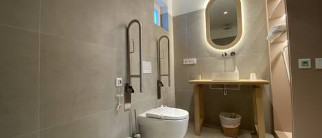 A modern bathroom with a toilet, bidet, and sink.