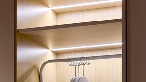 A closet with multiple shelves and a hanging rack. - Hotel Leonor (Conil de la Frontera)