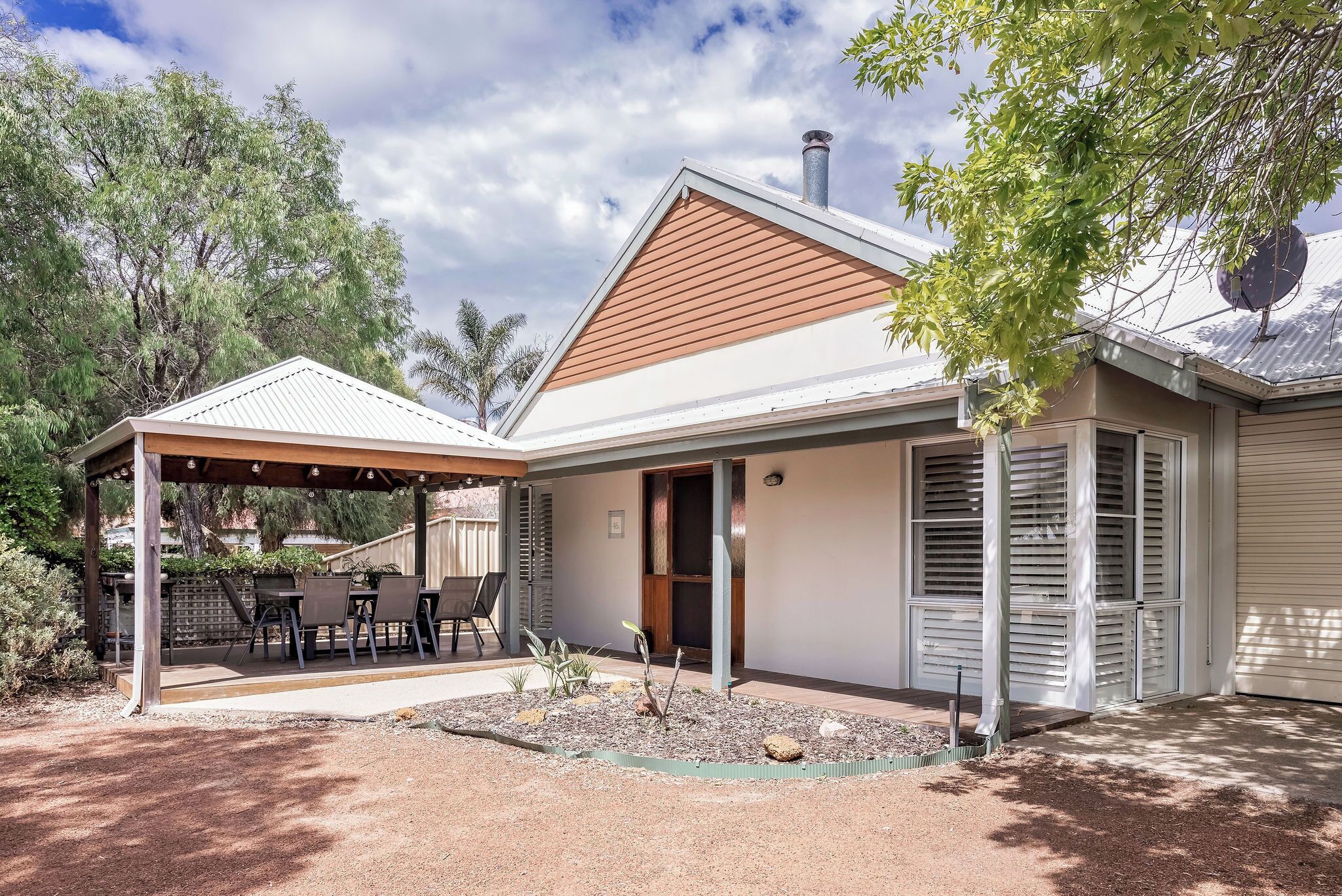 A house with a covered patio, a garden, and a garage.
