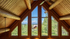 A log cabin with large windows offering a mountain view. - Beautiful Moran Home with spectacular Teton Views (Moran)