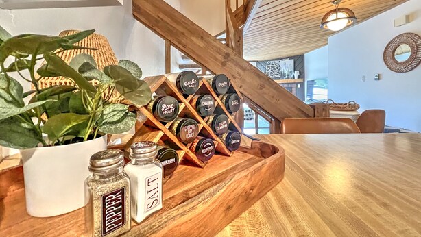 A wooden table with a potted plant, salt and pepper shakers, and a spice rack with various seasonings. - Modern Mountain Townhome with Mountain Views! (Mount Crested Butte)