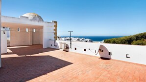 A rooftop terrace with a clear view of the sea, a white building with a dome, and a brick floor. - Apartment 'Romo' close to the Beach with Balcony & Wi-Fi (conil de la frontera)