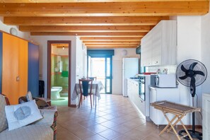 Un espace de vie compact comprenant une cuisine, un coin repas et une salle de bain.
