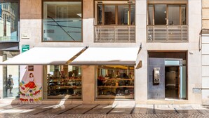 Un bâtiment doté d’une façade avec une vitrine, de grandes fenêtres et d’un trottoir pavé.