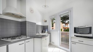 A modern kitchen with white cabinets, a gas stove, and a microwave. - Seafront, beautiful apartment for 4 with terrace (La Baule-Escoublac)