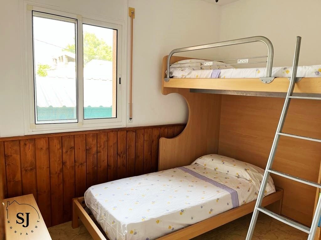 A small, single-bedded room with a bunk bed and a window.