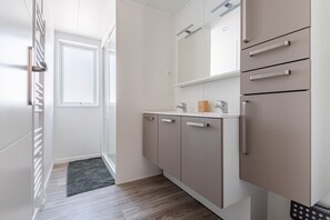 Eine moderne Küche mit weißen Schränken, einer Arbeitsplatte und einem eingebauten Backofen.