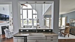 A kitchen with a central island, white cabinetry, and pendant lighting. - Beautiful Luxurious 4BD, 3.5 BA Home that sleeps 13 in the Bayside Golf & Resort Community! Amazing Pools, Fitness Centers, Tennis Courts, Walking trails, Freeman Stage with Music Performances! (Selbyville)
