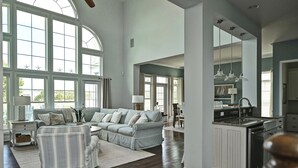 A spacious living room with a large sectional sofa, a dining area, and a kitchen with a central island. - Beautiful Luxurious 4BD, 3.5 BA Home that sleeps 13 in the Bayside Golf & Resort Community! Amazing Pools, Fitness Centers, Tennis Courts, Walking trails, Freeman Stage with Music Performances! (Selbyville)
