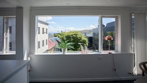 A room with a large window, a potted plant, and a lamp on the windowsill.