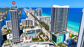 A high-rise hotel with a pool, beachfront view, and a marina.