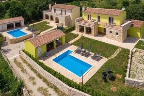 Uma villa com piscina, área de estar externa e jardim.