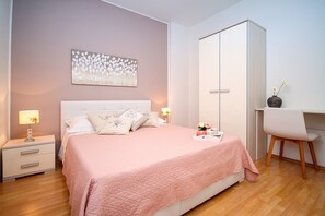 Una camera da letto con un letto, comodini, una scrivania e un armadio.