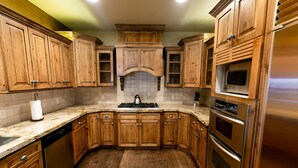 A kitchen with wooden cabinets, a stainless steel refrigerator, and a built-in oven. - Stein Eriksen Two Bedroom Loft 2 Apartment Hotel by RedAwning (Park City)