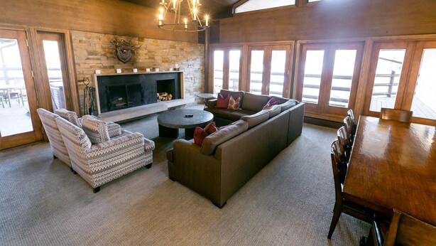 A spacious living room with a fireplace, a large sofa, a dining table, and a chandelier. - Stein Eriksen Two Bedroom Loft 2 Apartment Hotel by RedAwning (Park City)