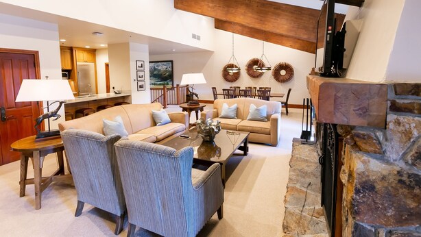 A spacious living area with a large sofa, a coffee table, and a fireplace. - Luxury Four Bedroom Multi-Level Townhouse 4 Townhouse by RedAwning (Park City)