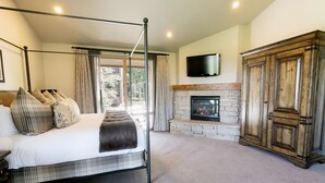 Un dormitorio con cama con dosel, chimenea de piedra y un gran armario de madera.