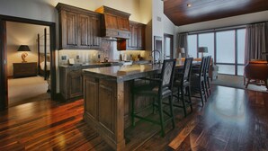 A spacious kitchen with wooden cabinets, a large island, and a dining area with chairs.