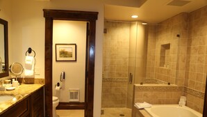 A bathroom with a marble sink, a bathtub, a shower, and a toilet.