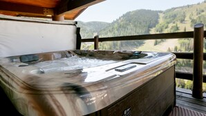 A hot tub on a wooden deck with a view of a forested mountain range. - Luxury One Bedroom with Mountain View 1 Apartment Hotel by RedAwning (Park City)